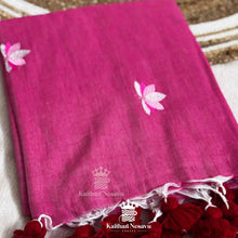 Pink saree with floral embroidery on a textured surface