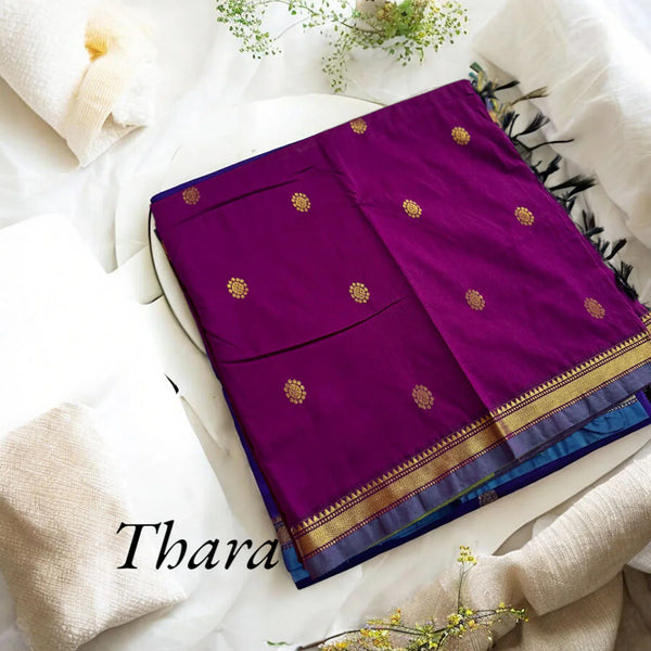 Purple saree with gold patterns on a white fabric background
