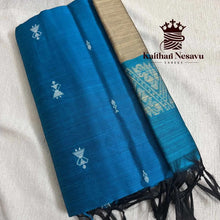 Blue handloom cotton saree with white motifs and gold pallu on light fabric background