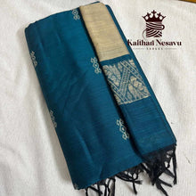 Folded blue handloom silk saree with golden border and traditional motifs on a white background