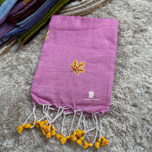 Purple saree with yellow leaf design and fringes on a textured surface