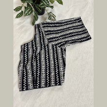 Black and white handloom cotton blouse with zigzag and vine patterns on a light fabric background