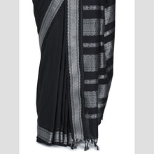 Black saree with white patterns on a light gray background