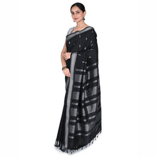 Woman wearing a black and gray saree with a white background