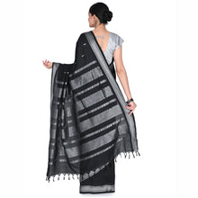 Woman wearing a black and gray striped saree on a white background
