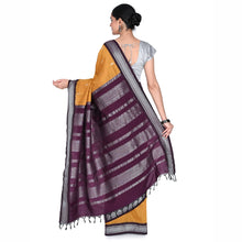 Woman wearing a purple and yellow saree with a white background