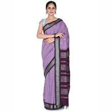 Woman wearing a purple saree with a black border on a white background