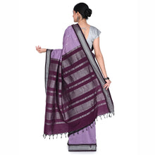 Woman wearing a purple and gray striped saree on a white background