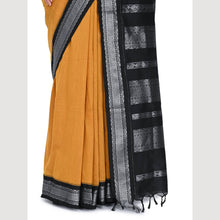 Mustard yellow saree with black and white border on a light gray background