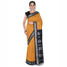 Woman wearing a mustard yellow saree with black border on a white background
