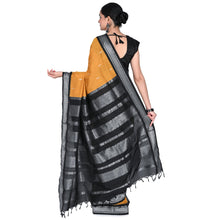 Woman wearing a black and yellow saree with a white background
