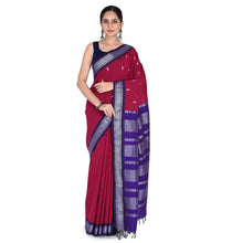 Woman wearing a red and purple saree with a white background