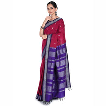 Woman wearing a red and purple saree with a white background
