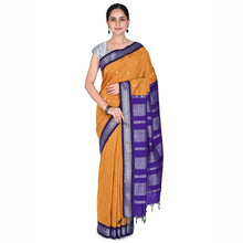 Woman wearing a yellow saree with a purple border on a white background
