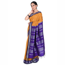 Woman wearing a yellow and purple saree with a white background