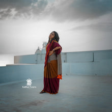 Woman in a traditional saree standing on a rooftop with a cloudy sky